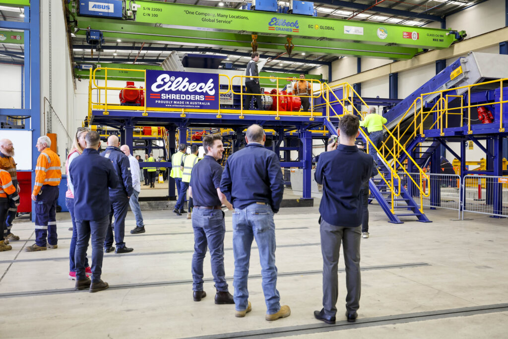 Open day guests gather on the workshop floor in front of the processing line