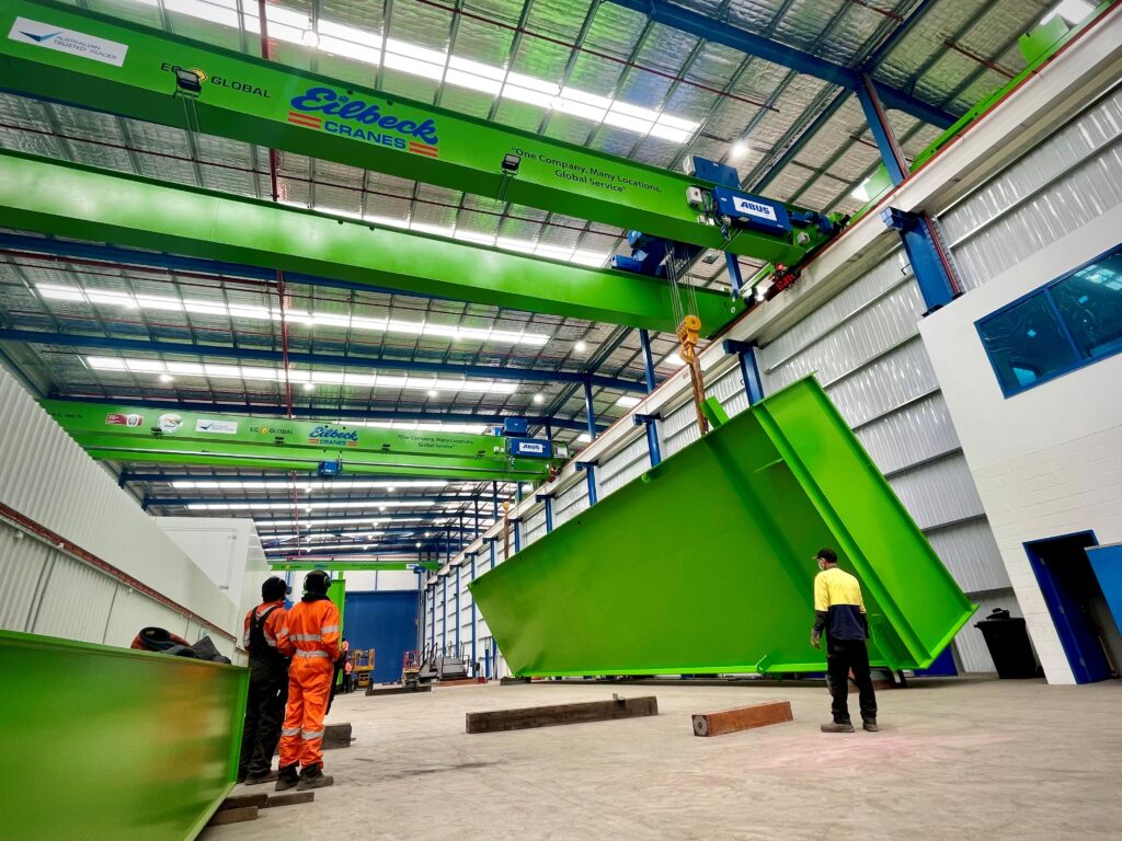 An Eilbeck overhead crane lifts a large green steel fabrication in the Moss Vale workshop